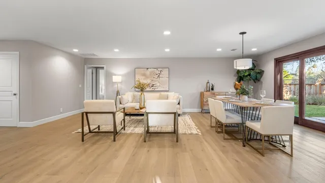 a living room with stainless steel appliances kitchen island granite countertop furniture and a wooden floor
