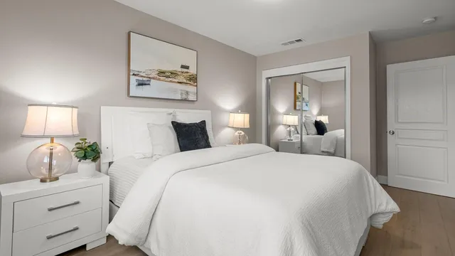 a bedroom with a large bed and a potted plant