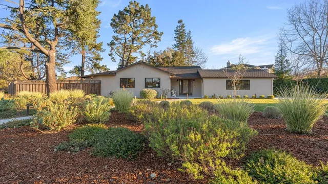 a front view of house with yard and trees around