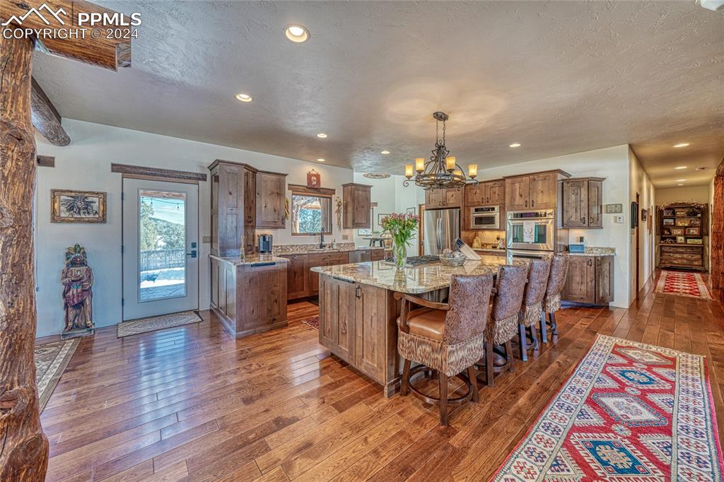 1328 Round Up Road Westcliffe, CO 81252 - Photo 12 of 50 a living room with lots of wooden furniture and kitchen view