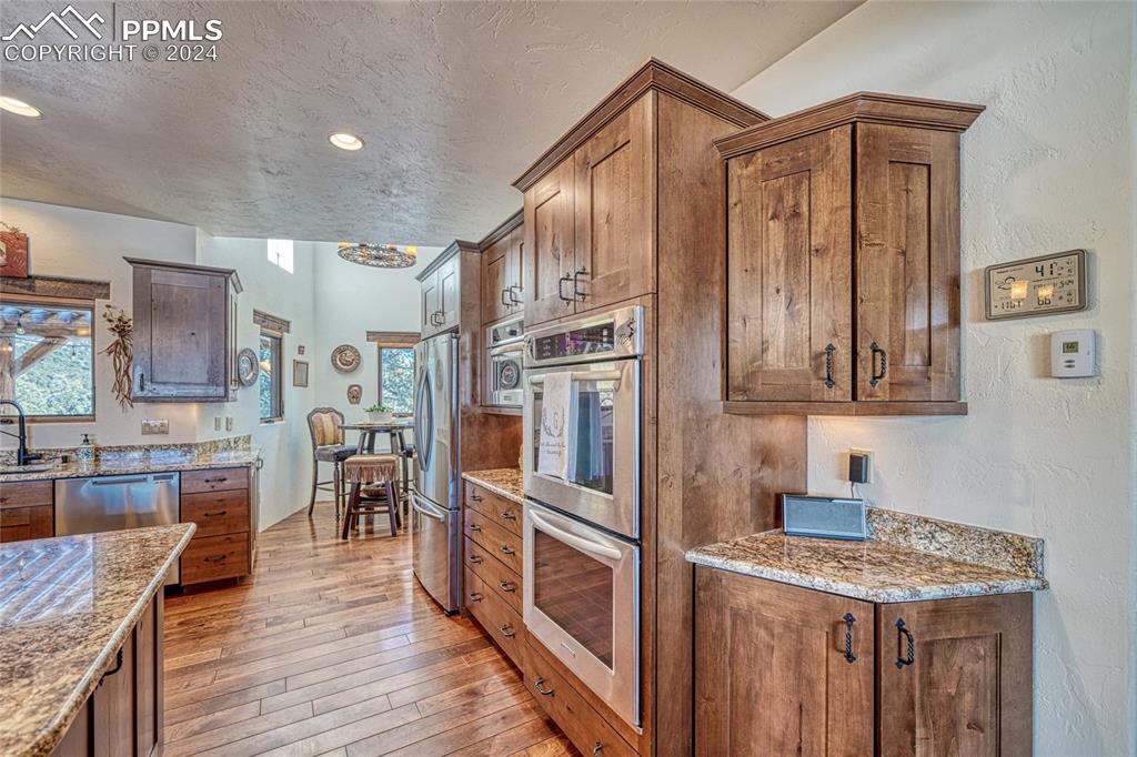 1328 Round Up Road Westcliffe, CO 81252 - Photo 18 of 50 a kitchen with stainless steel appliances granite countertop lots of counter top space and wooden floor
