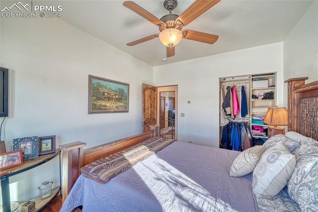 1328 Round Up Road Westcliffe, CO 81252 - Photo 34 of 50 a bedroom with bed and a chandelier