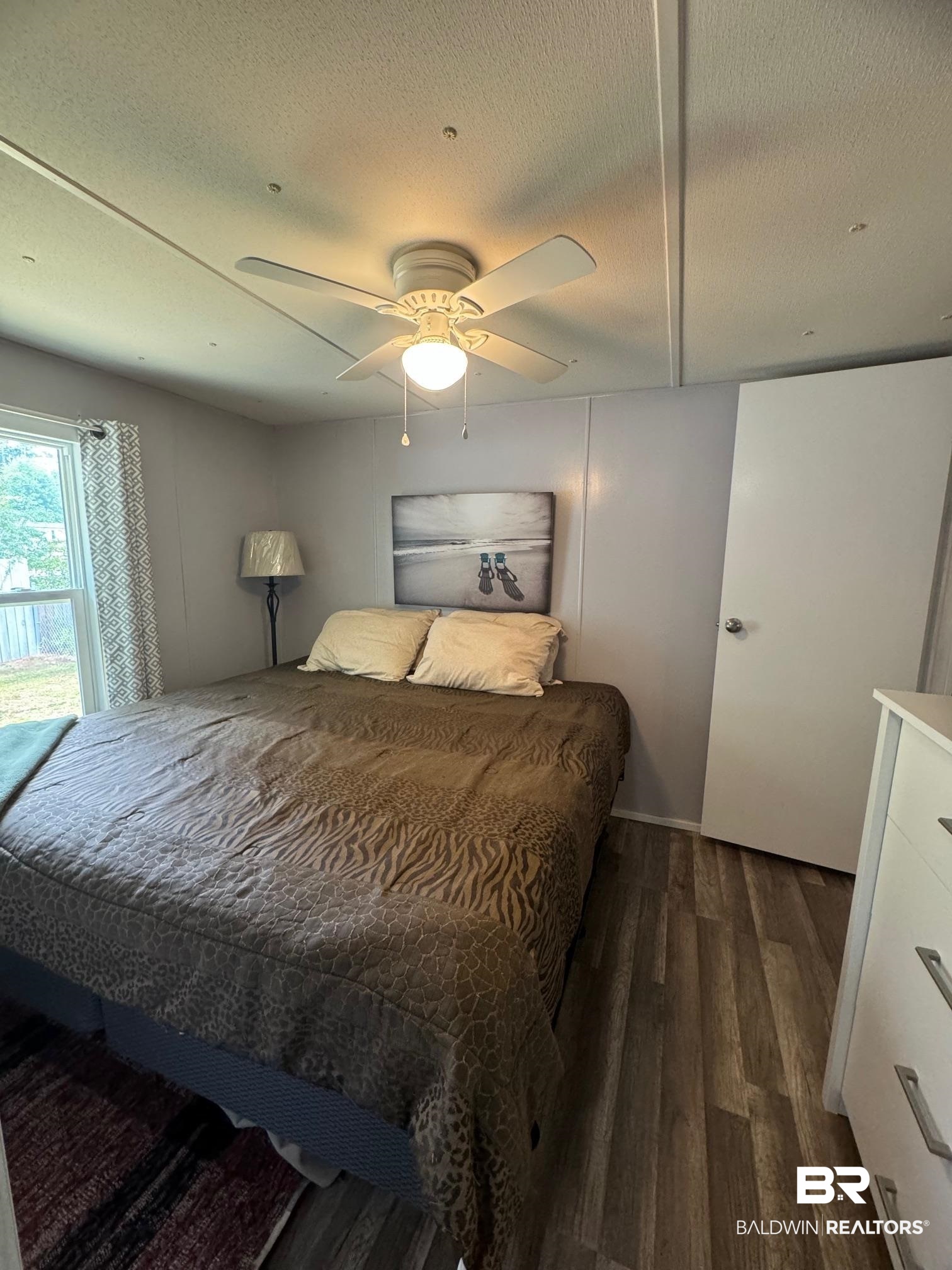 1420 Ridgewood Circle Lillian, AL 36549 - Photo 8 of 41 Bedroom featuring dark wood-type flooring, ceiling fan, and a textured ceiling