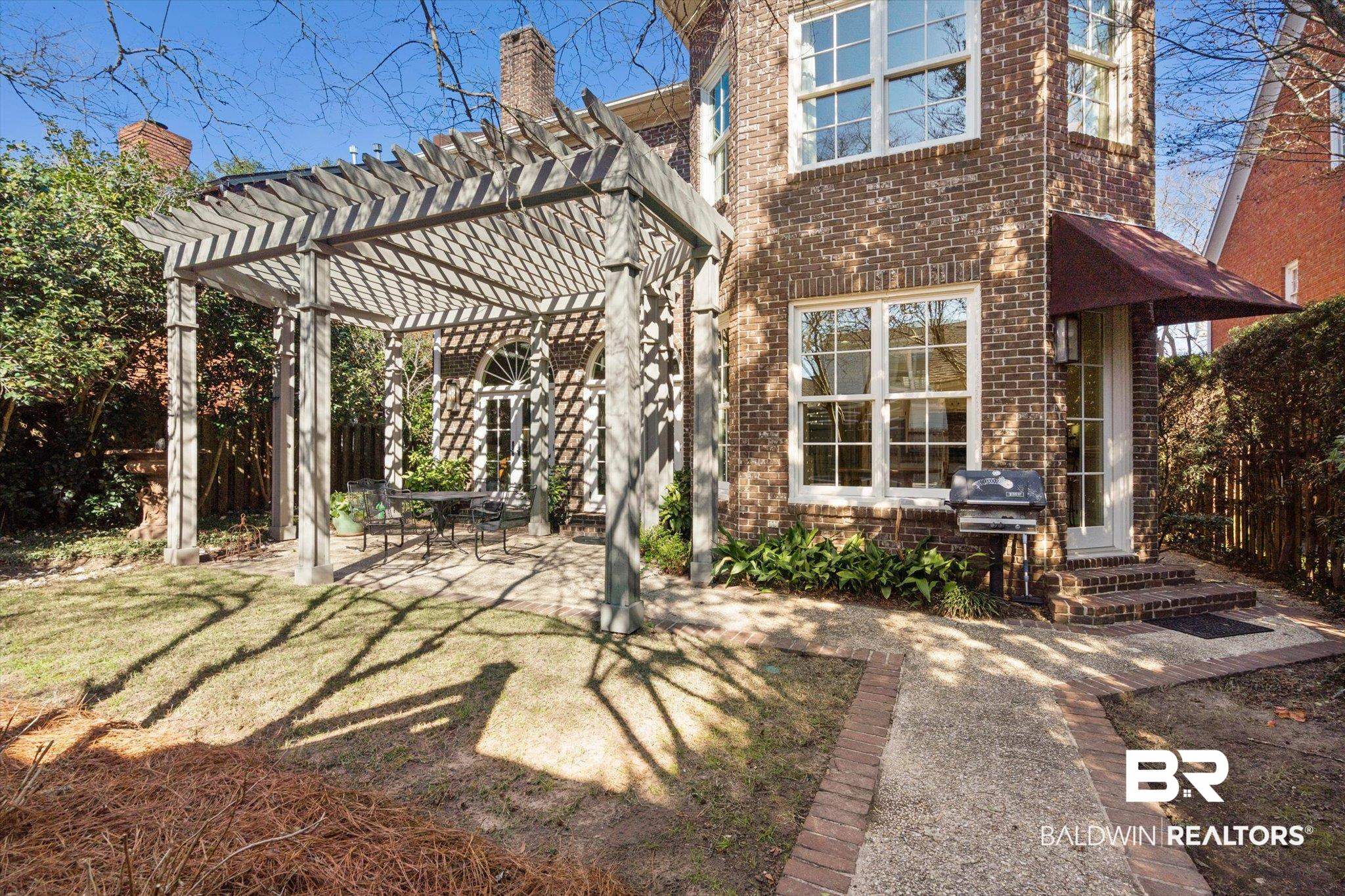 3615 Stein Street Mobile, AL 36608 - Photo 38 of 44 Rear view of house featuring a pergola, brick siding, outdoor dining space, and a patio