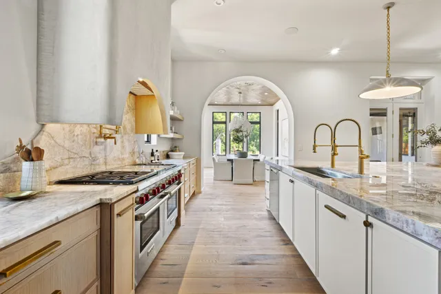 a open kitchen with stainless steel appliances granite countertop a stove a sink and a wooden floors