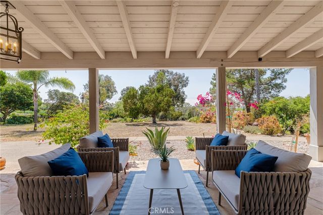 a view of a patio with couches chairs and wooden floor