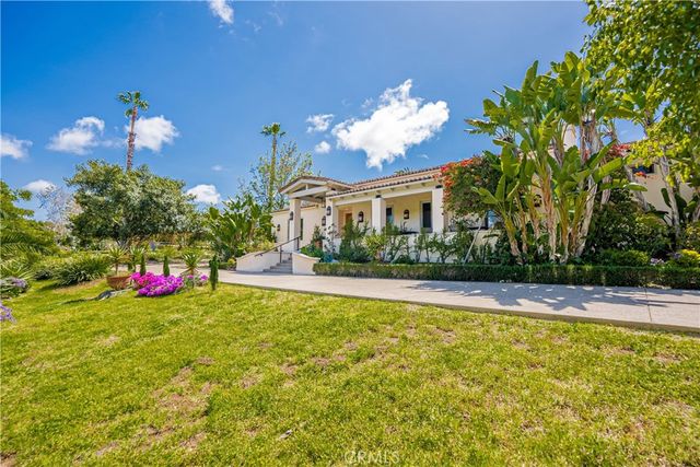 a view of a house with swimming pool lawn chairs and a yard