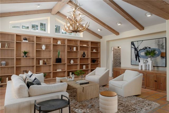 a living room with furniture potted plant and a large window