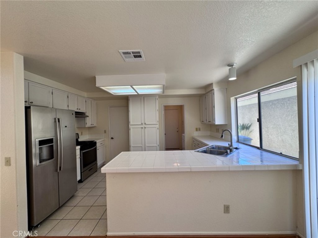 31585 Corte Salinas Temecula, CA 92592 - Photo 11 of 42 a kitchen with stainless steel appliances a refrigerator and wooden floor