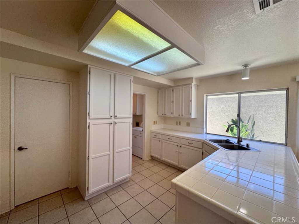 31585 Corte Salinas Temecula, CA 92592 - Photo 12 of 42 a kitchen with white cabinets and window