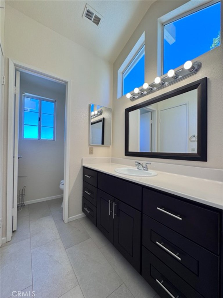 31585 Corte Salinas Temecula, CA 92592 - Photo 27 of 42 a bathroom with a granite countertop double vanity sink and a mirror