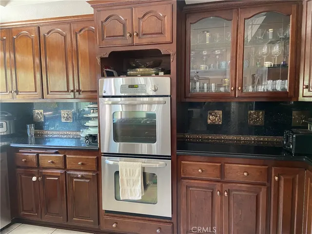 a kitchen with stainless steel appliances granite countertop a refrigerator and a stove