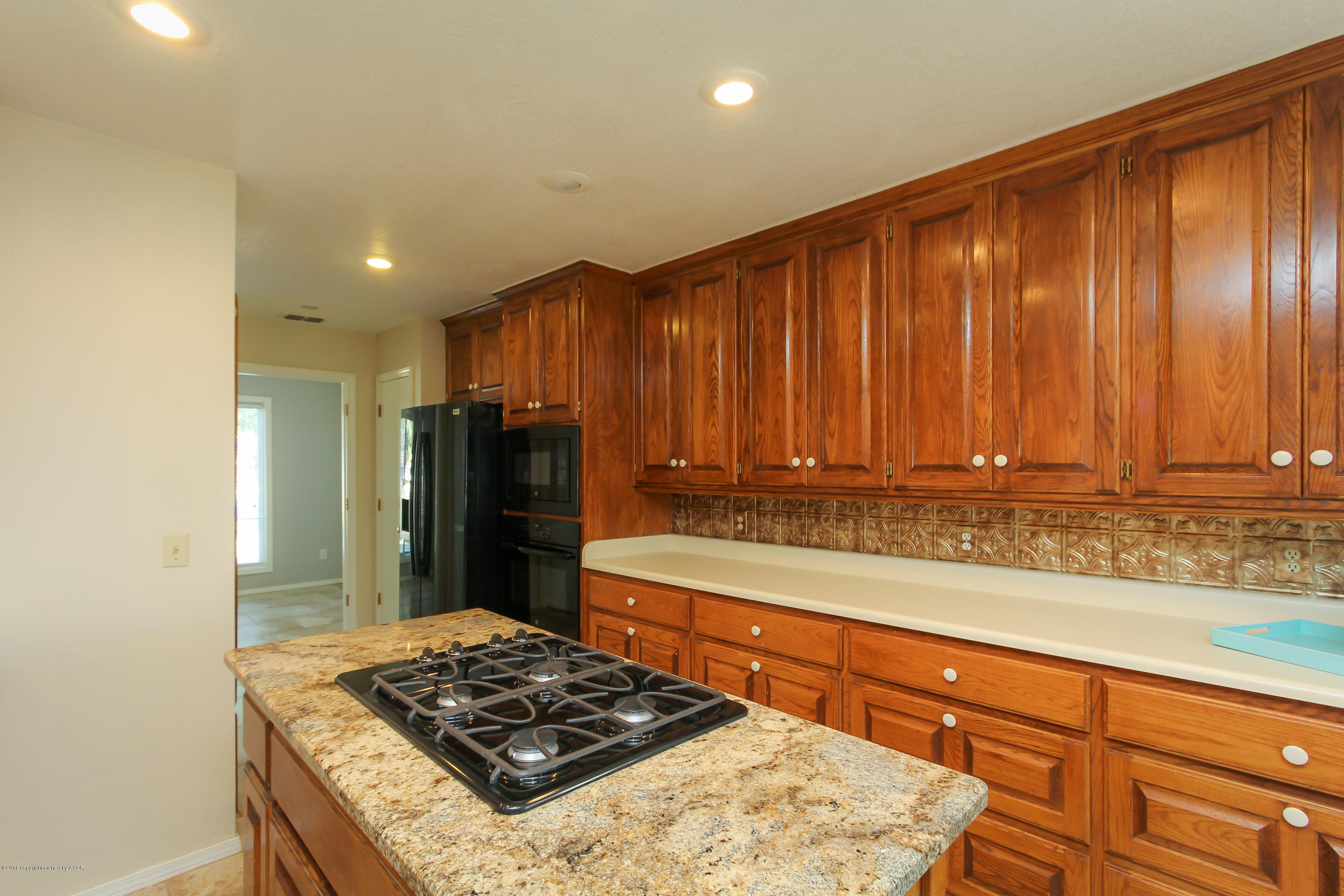 7915 Santa Fe Trail Amarillo, TX 79110 - Photo 11 of 57 a kitchen with wooden cabinets and a stove top oven