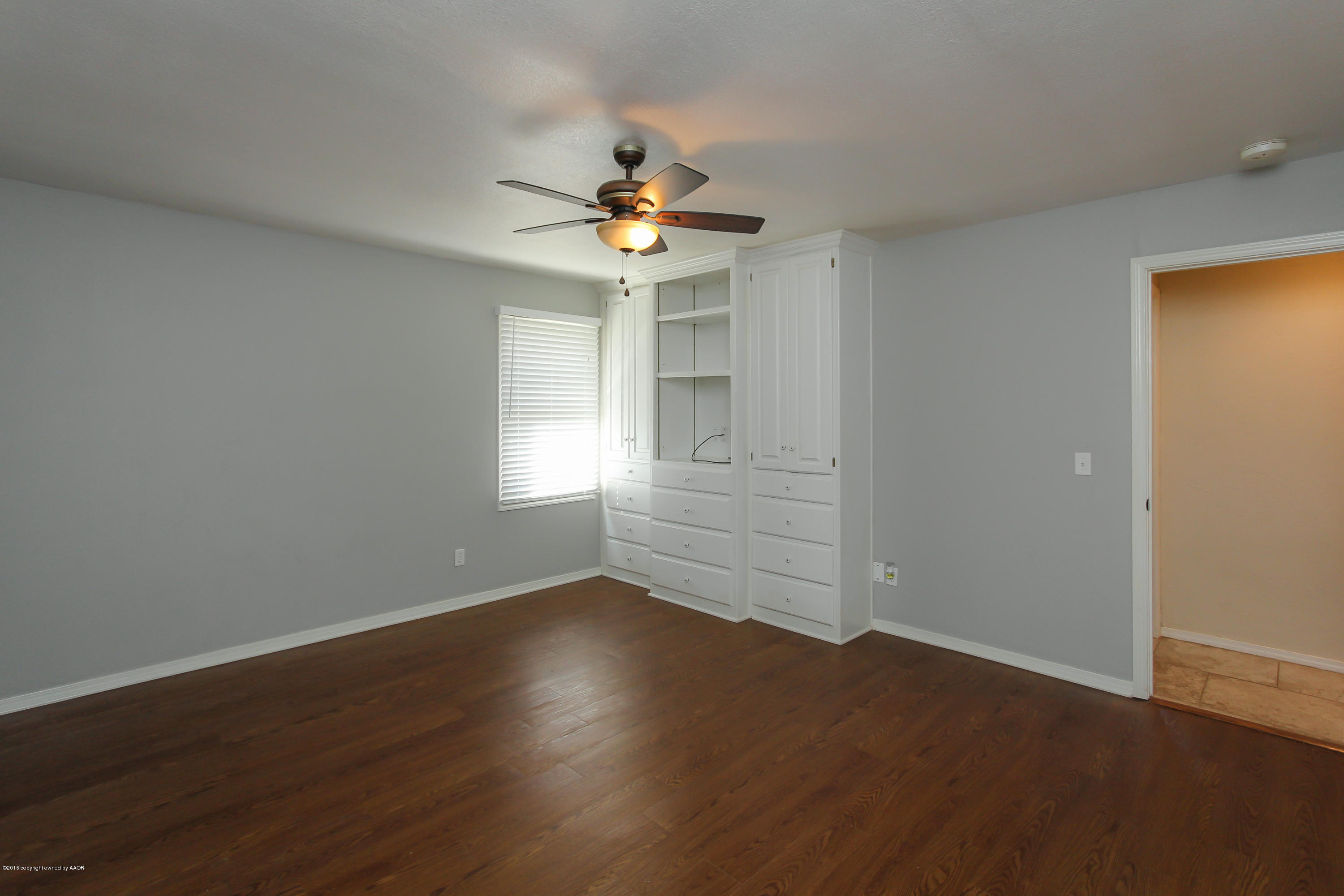 7915 Santa Fe Trail Amarillo, TX 79110 - Photo 22 of 57 an empty room with wooden floor chandelier fan and windows