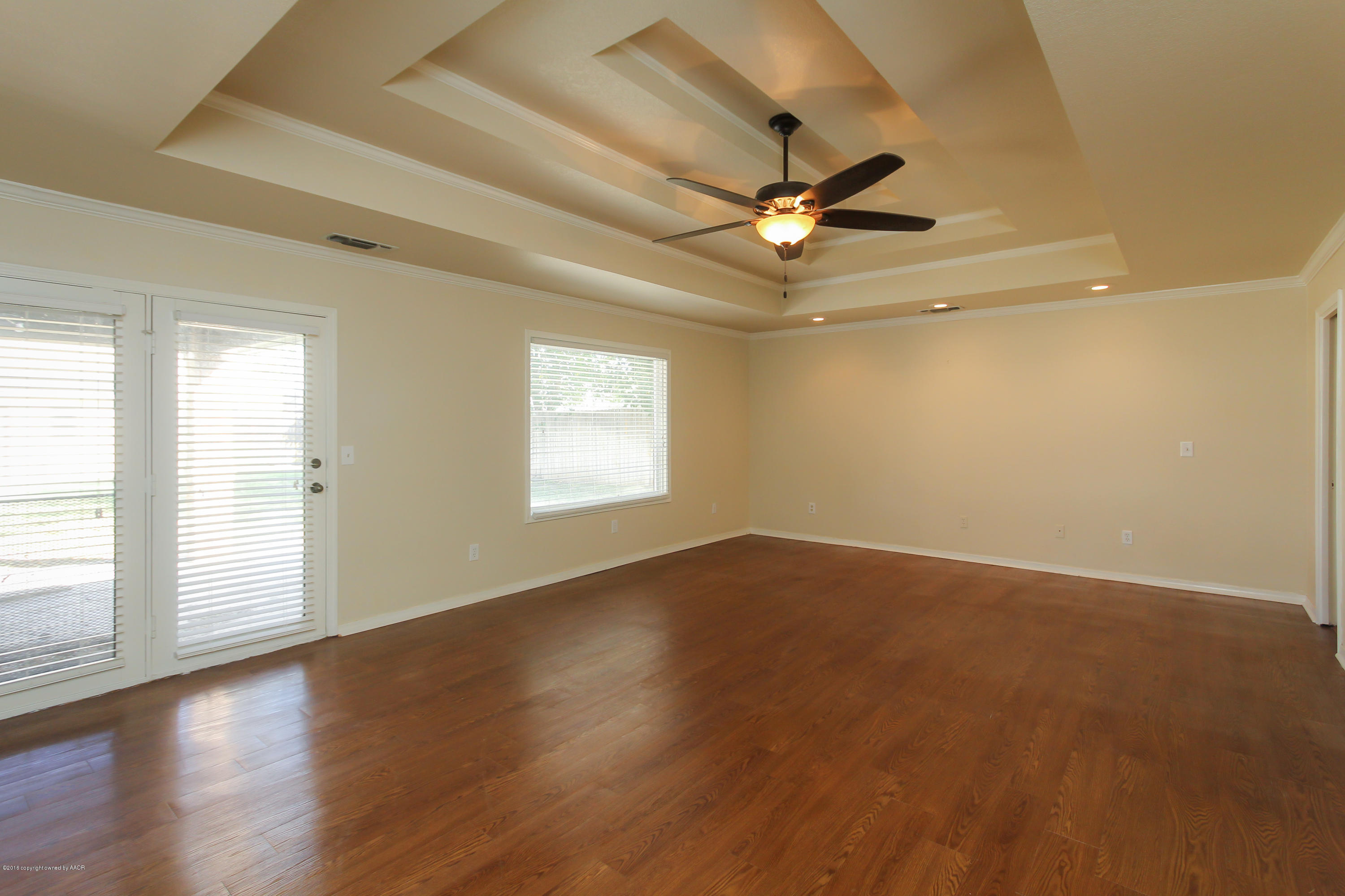 7915 Santa Fe Trail Amarillo, TX 79110 - Photo 42 of 57 an empty room with wooden floor fan and windows