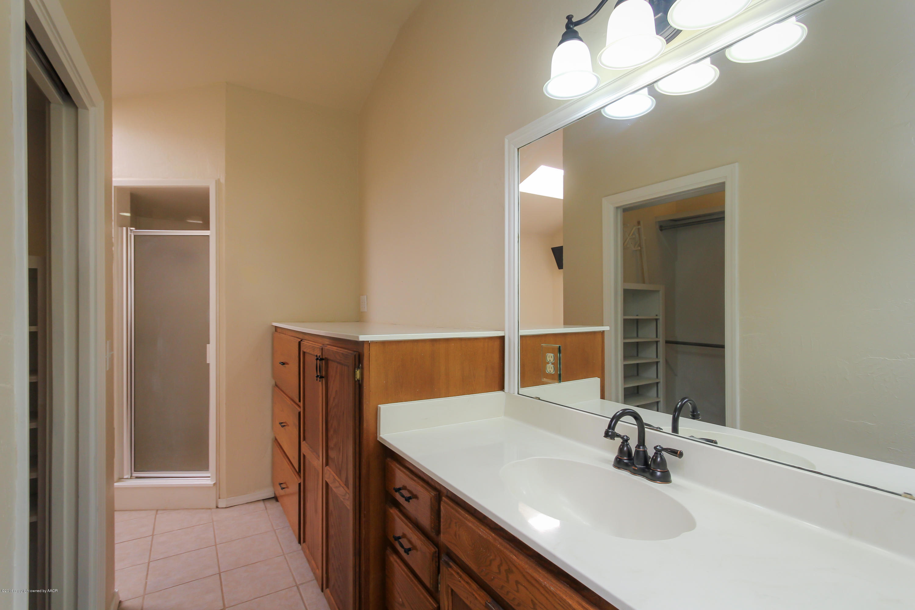 7915 Santa Fe Trail Amarillo, TX 79110 - Photo 44 of 57 a bathroom with a sink a light fixture and a mirror