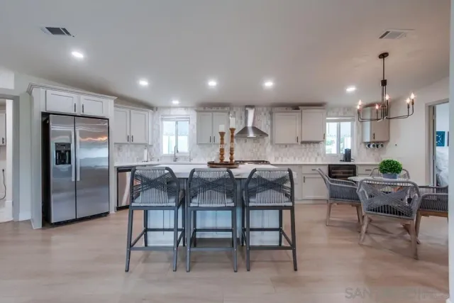 a kitchen with stainless steel appliances granite countertop a stove a sink dishwasher and a refrigerator