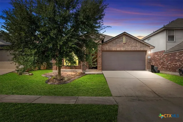 a front view of a house with a yard and trees