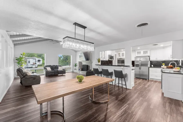 a view of a dining room with furniture a rug and wooden floor