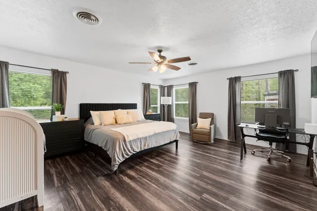 a spacious bedroom with a bed a table and a large window