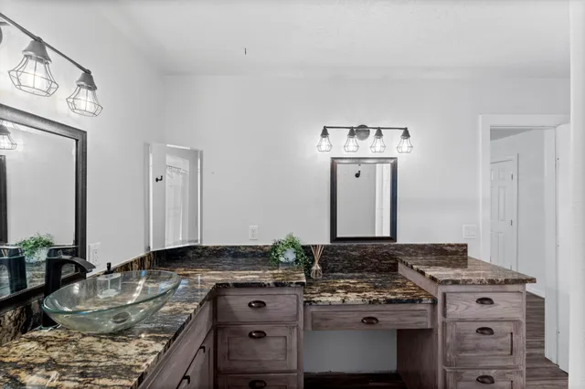 a kitchen with granite countertop a stove and cabinets