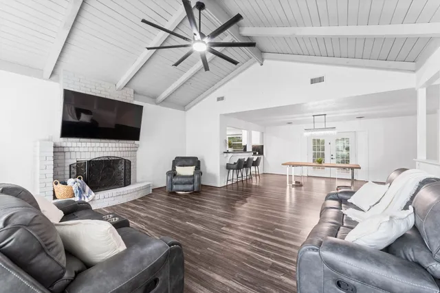 a living room with furniture a flat screen tv and a fireplace