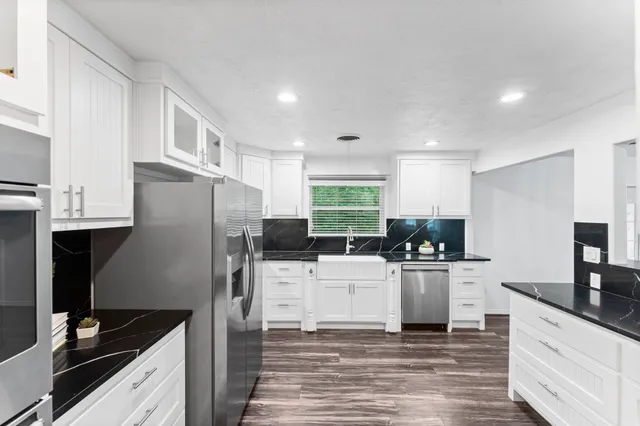 a kitchen with a refrigerator and a stove top oven
