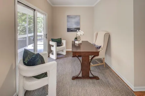 a living room with furniture a rug potted plant and a large window