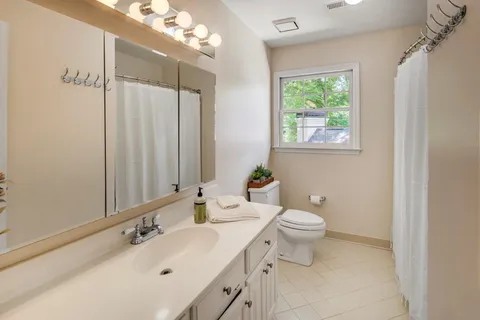 a bathroom with a toilet sink and mirror