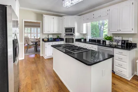 a kitchen with white cabinets and appliances