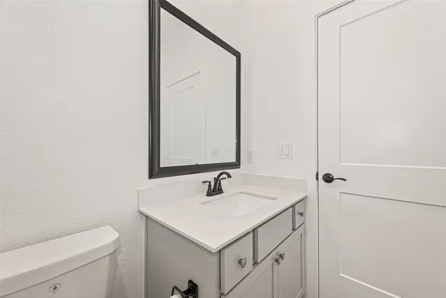 a bathroom with a sink toilet and mirror