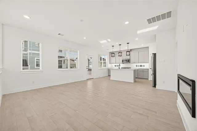 a view of a kitchen with center island and stainless steel appliances