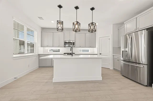 a kitchen with kitchen island white cabinets and refrigerator
