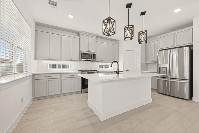 a kitchen with a refrigerator and white cabinets