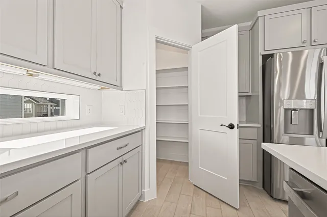 a kitchen with white cabinets and refrigerator