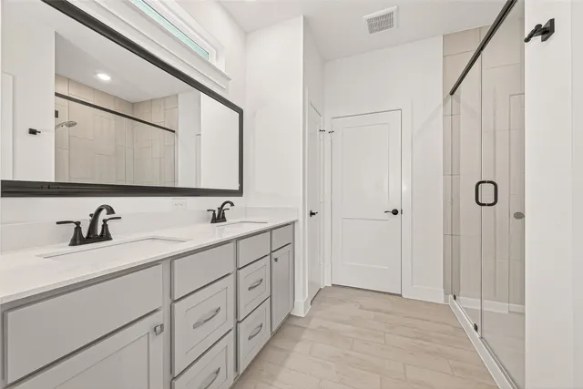 a bathroom with a double vanity sink and a mirror