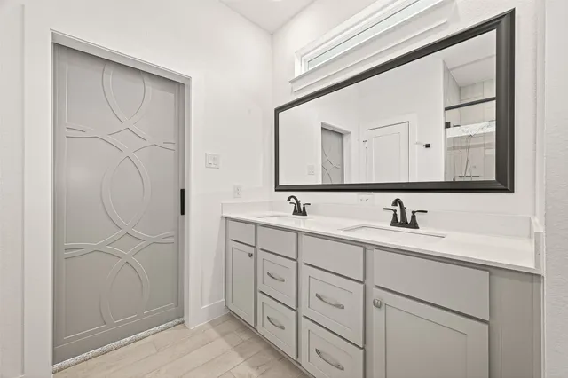 a bathroom with a double vanity sink and a mirror