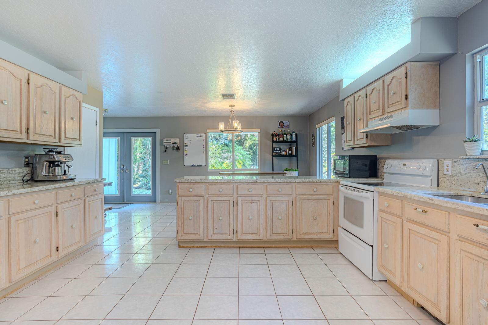 4852 Windmill Road Loxahatchee, FL 33470 - Photo 3 of 12 a kitchen with cabinets and window