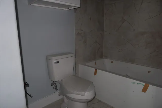 a white toilet sitting next to a bathtub