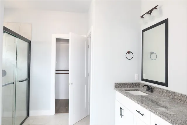 a bathroom with a granite countertop sink and mirror