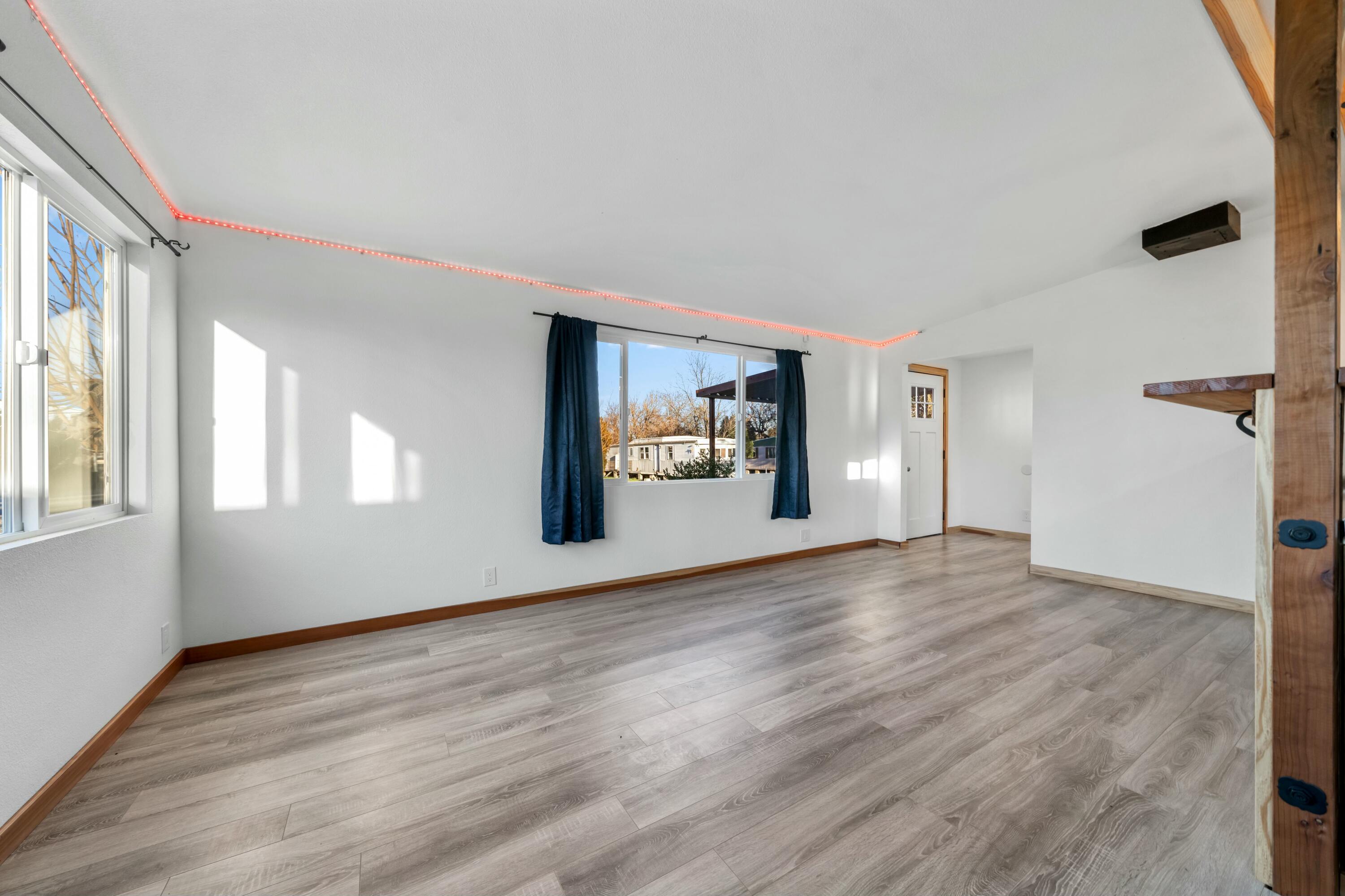 22235 Lone Tree Road, Unit 4 Anderson, CA 96007 - Photo 6 of 15 a view of an empty room with a window and wooden floor