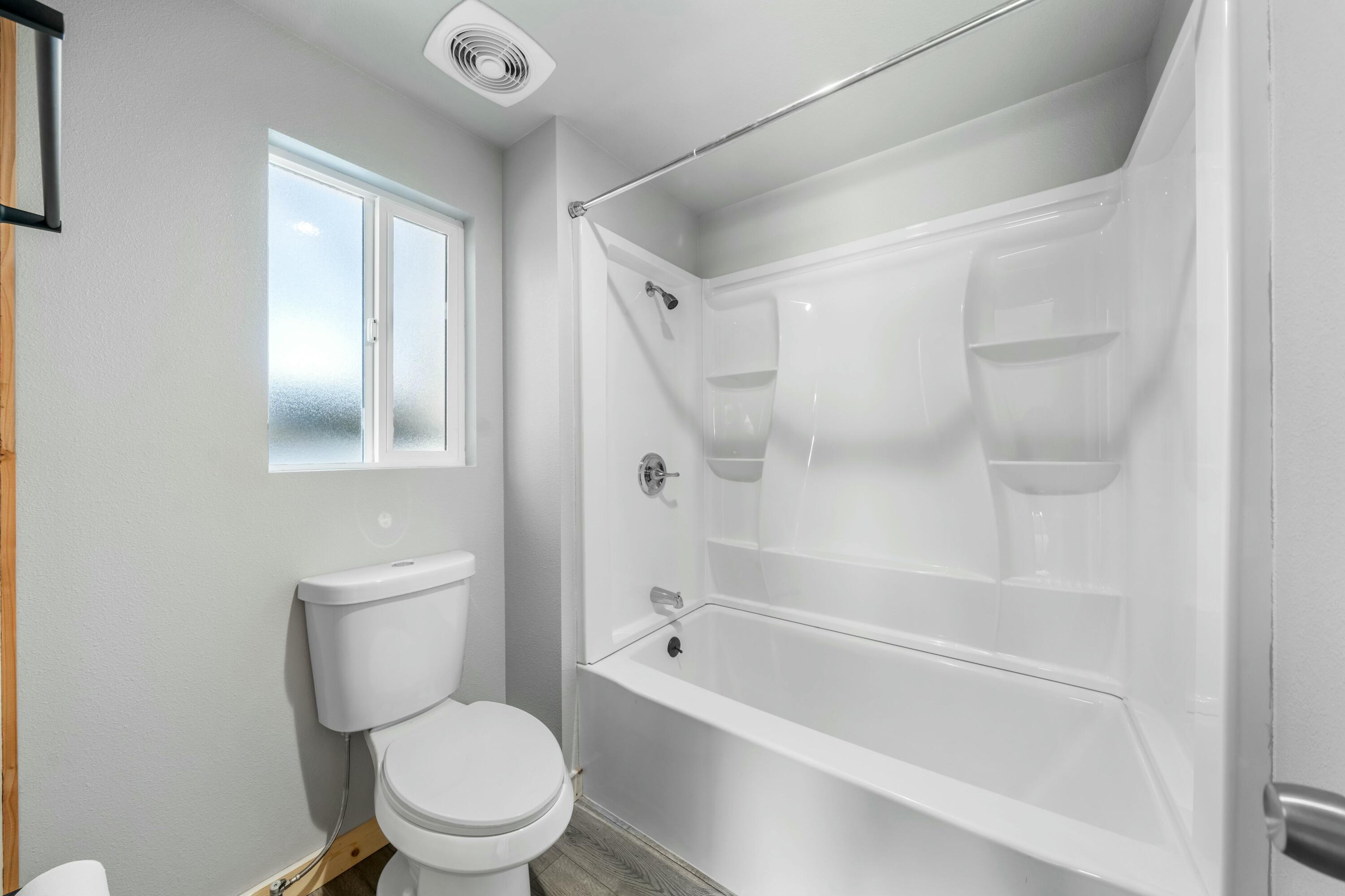 22235 Lone Tree Road, Unit 4 Anderson, CA 96007 - Photo 9 of 15 a white toilet sitting next to a bath tub