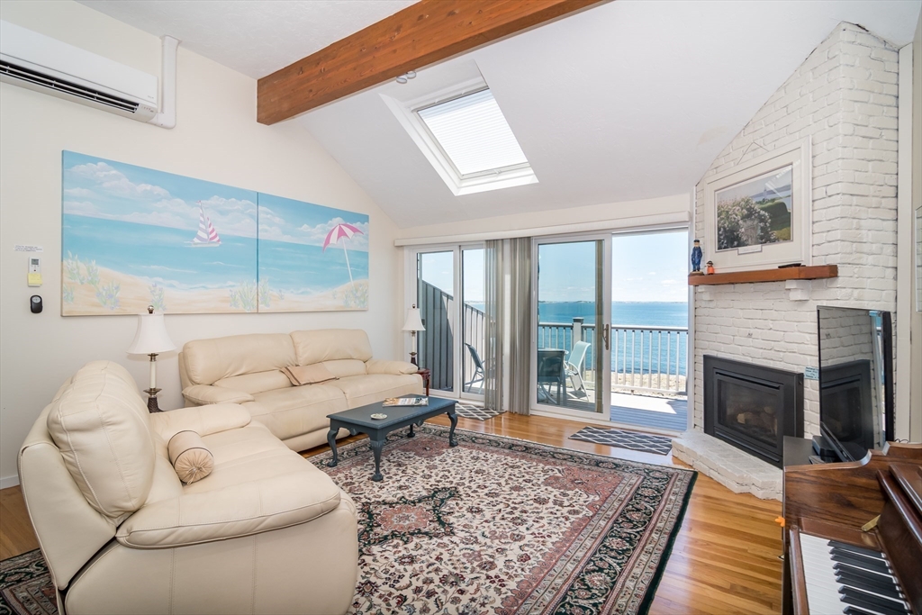 22 Oceanside Drive, Unit 22 Hull, MA 02045 - Photo 12 of 37 a living room with furniture or couch and a fireplace