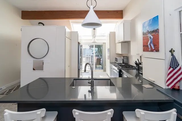 a kitchen with stainless steel appliances granite countertop a sink a stove and a wooden floors