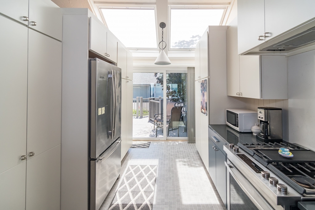 22 Oceanside Drive, Unit 22 Hull, MA 02045 - Photo 19 of 37 a kitchen with stainless steel appliances granite countertop a refrigerator and a stove