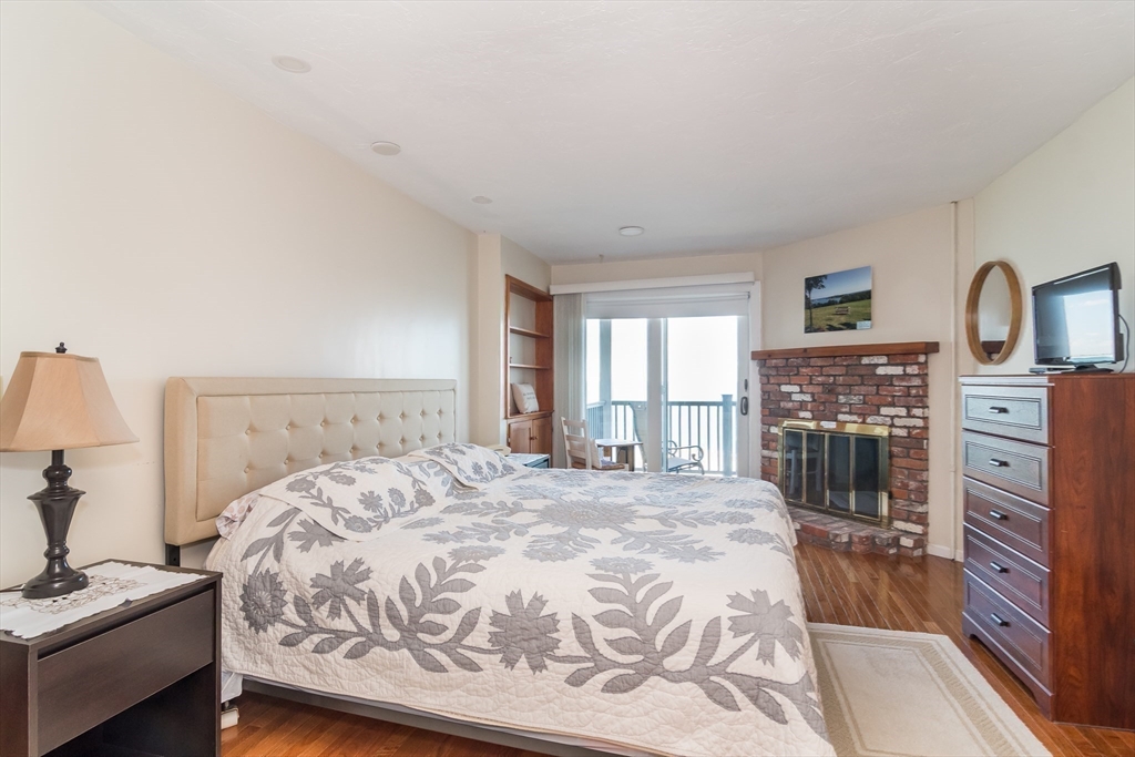 22 Oceanside Drive, Unit 22 Hull, MA 02045 - Photo 22 of 37 a spacious bedroom with a bed and a dresser in it