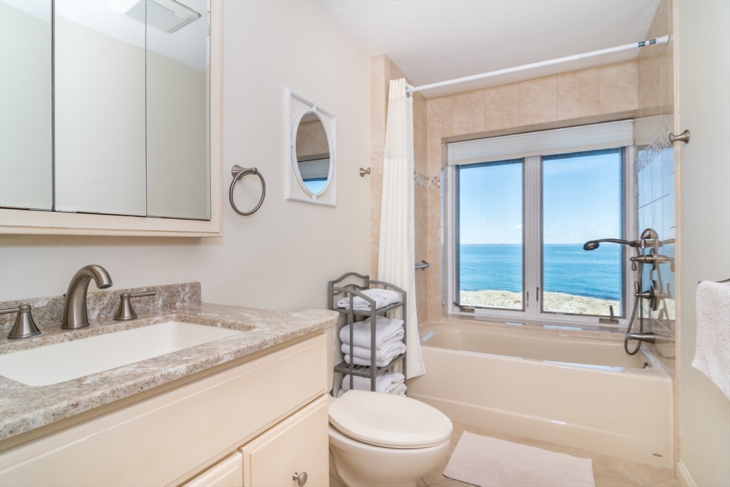 22 Oceanside Drive, Unit 22 Hull, MA 02045 - Photo 24 of 37 a bathroom with a granite countertop sink mirror toilet and bathtub
