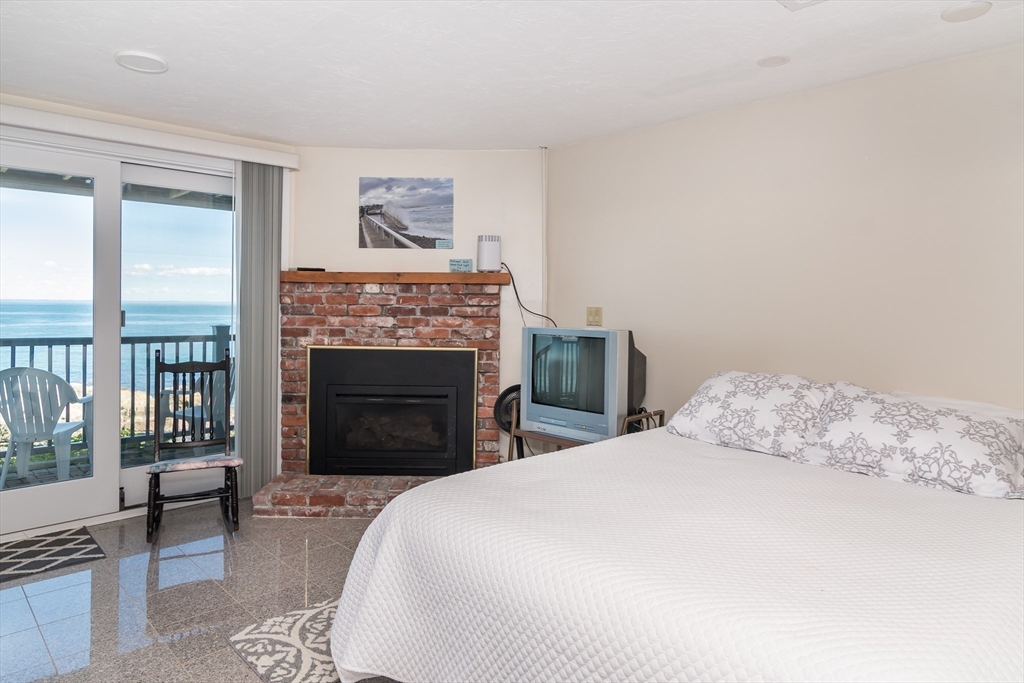 22 Oceanside Drive, Unit 22 Hull, MA 02045 - Photo 33 of 37 a bedroom with a bed and a fireplace