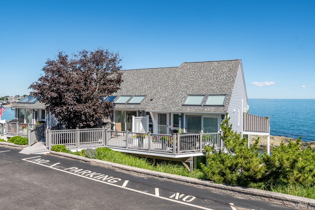 22 Oceanside Drive, Unit 22 Hull, MA 02045 - Photo 6 of 37 a front view of a house with a garden and plants