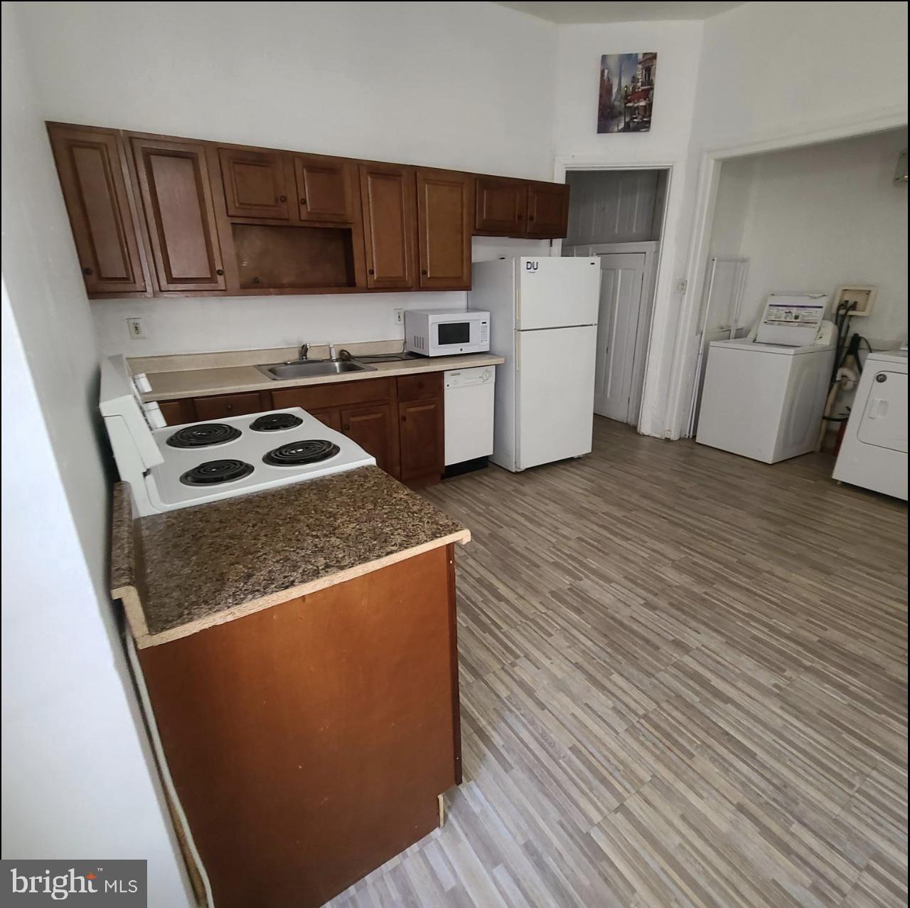433 North 33rd Street Philadelphia, PA 19104 - Photo 11 of 27 a kitchen with a refrigerator a stove top oven a counter space and wooden floor